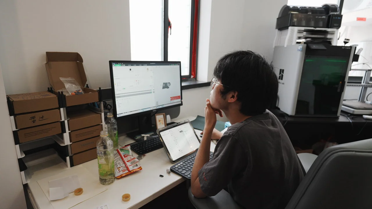 工作台旁操作计算机的加工准备场景