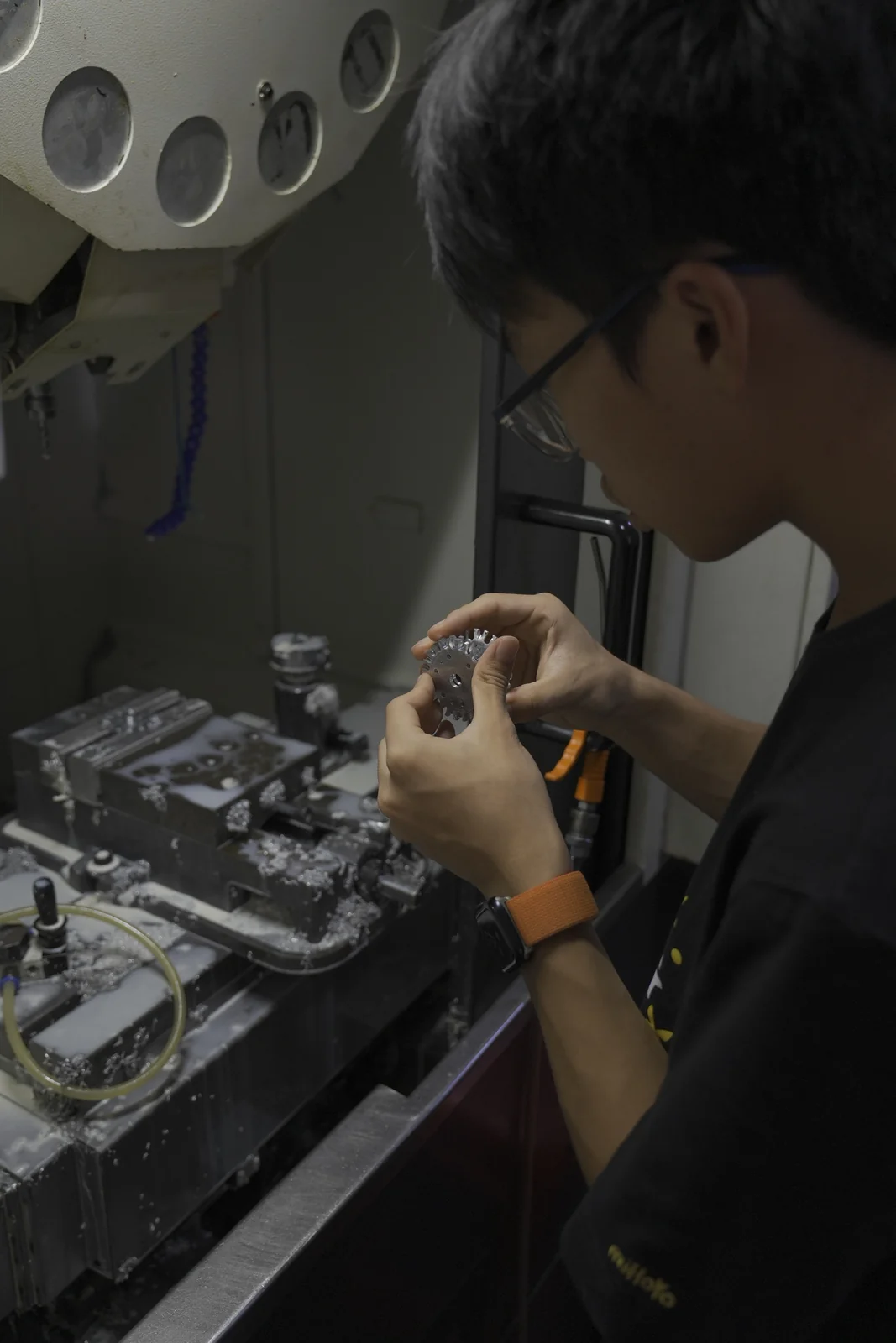 在机床旁用手检查加工后的机械零件
